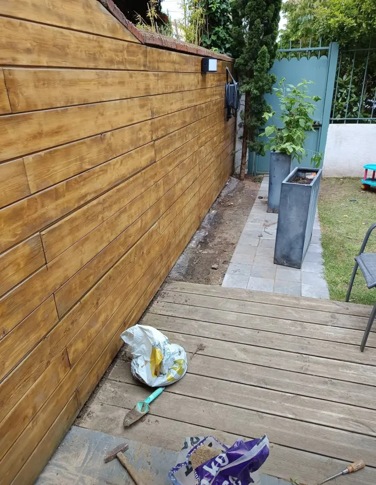 Borne V2C posée sur le bardage bois au fond d'un jardin à Poissy